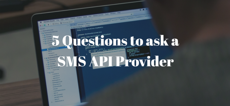 A photo of a programmer writing code on his lapop. there is white text above it that shows the title: 5 Questions to ask a SMS API Provider