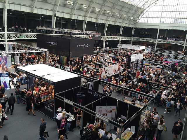 4 SMS Text-Marketing Campaign Types For Events & Trade Shows Large crowd at a trade show. A small group look to be engaging in SMS Trade Show campaigns.