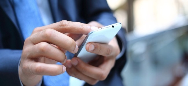 Why use international texting apps? Close up of a man using mobile smart phone
** Note: Shallow depth of field